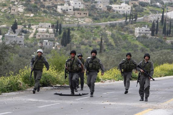 Israeli border policemen run towards Palestinian stone-throwers during clashes outside the West Bank Palestinian village of Awarta, near Nablus March 22, 2011. Israeli troops have been operating in the area since the fatal stabbings of a Jewish couple and three of their children in a nearby West Bank settlement on March 12, in what Israel says was an attack by Palestinian militants. REUTERS/Abed Omar Qusini (WEST BANK - Tags: POLITICS CIVIL UNREST)