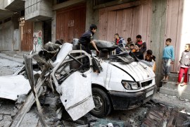 Children climb on destroyed car in Gaza