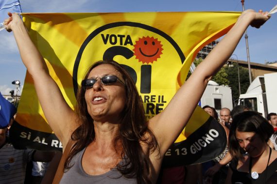 A woman holds an anti-nuclear flag following partial results of four referendums