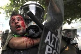 Athens riot police hold anti-austerity protester