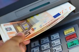 Fifty Euro notes are pictured coming out of an ATM machine
