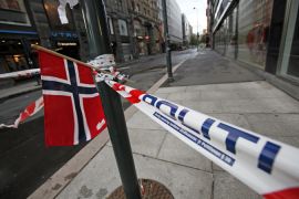 Norwegian flag on empty street, taped off by police, in central Oslo following bomb blast