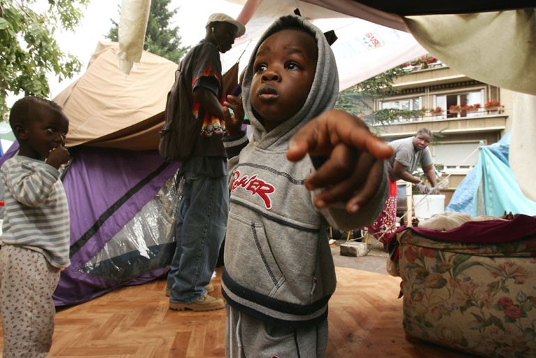An african boy stands in his tented camp