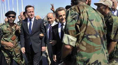 Cameron, second left, and French President Nicolas Sarkozy, fourth left, are greeted by the National Transitional Council head Mustafa Abdul Jalil, between them, and pro-NTC combatants as they arrive at the Tripoli Medical Centre in September 2011 [Reuters]