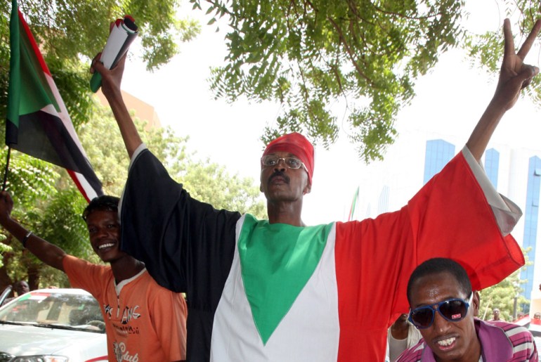 Man in Sudanese flag celebrates