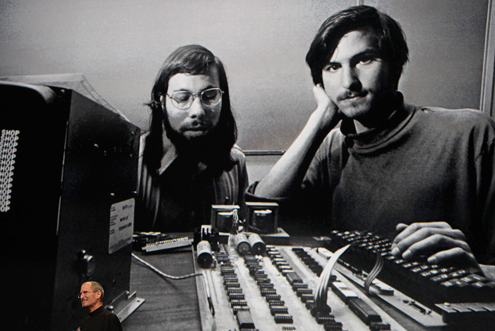 Jobs stands beneath a photograph of him and Apple-cofounder Steve Wozniak from the early days of Apple during the launch of Apple's new 'iPad' in San Francisco on January 27, 2010 [Reuters]
