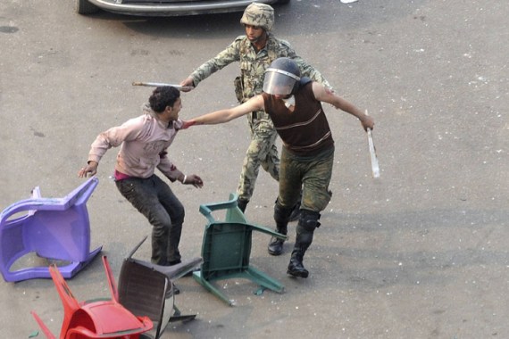 Egyptian army soldiers arrest a protester (L) during clashes at Tahrir Square in Cairo December 17, 2011.