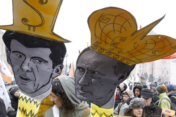 A man holds caricatures of Russian Prime Minister Vladimir Putin (R) and billionaire and presidential candidate Mikhail Prokhorov during a rally demanding a fair election in St.Petersburg February 26, 2012. Russians will go to the polls to elect a new president on March 4. REUTERS