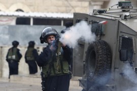 An Israeli policeman fires a tear gas canister during clashes with Palestinian protesters at a demonstration against the closure of Shuhada street to Palestinians, in the West Bank city of Hebron February 24, 2012. Some 200 protesters, including foreign and Israeli activists, gathered on Friday marking the 18th anniversary of the closure of the street, which was closed by the Israeli army in 1994 following the Hebron mosque massacre by Baruch Goldstein