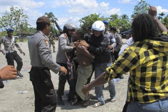 Police arrest a man after dispersing West Papuans attending ceremony to commemorate 50th anniversary of West Papua''s independence from Dutch rule in Timika