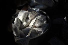 Police officers open packages filled with chemical precursors, used to manufacture synthetic drugs, to be incinerated in Guatemala City