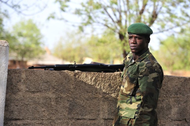 A Malian soldier takes position as junta