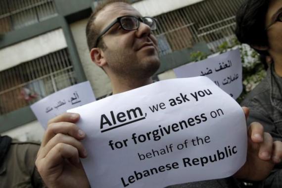 A Lebanese activist holds a sign in refe