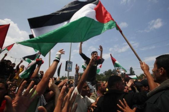 Palestinians shout slogans during a protest to mark