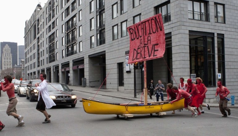 Students push a canoe across the street as they protest against tuition hikes in downtown Montreal