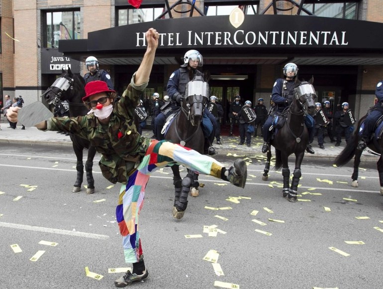 A protester demonstrates in front of police during the annual general meeting of Power Corporation of Canada in Montreal