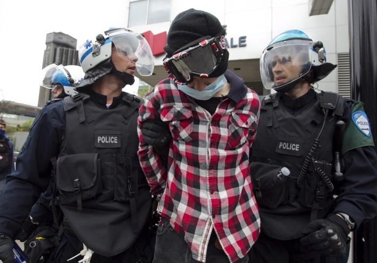 A protester is arrested by police during a demonstration against tuition hikes in Montreal