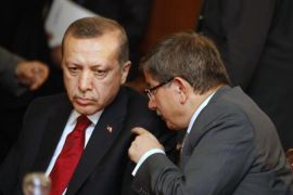 Turkey''s FM Davutoglu speaks with Turkish PM Erdogan during a meeting at the government palace in Tunis