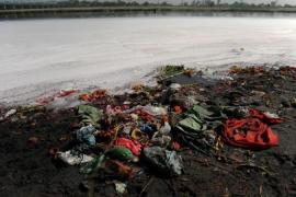 Plastic bags and garbage lie on the bank