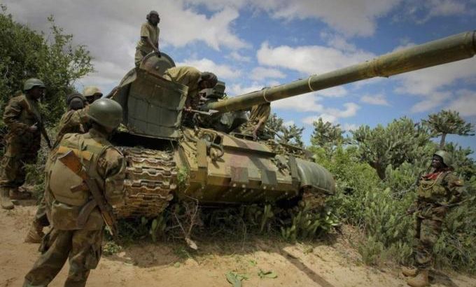 Ugandan soldiers serving with the African Union Mission in Somalia (AMISOM) stand around a tank near the outskirts of the town of Afgoye