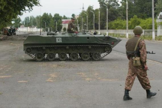 Uzbek soldiers patrol around an armored