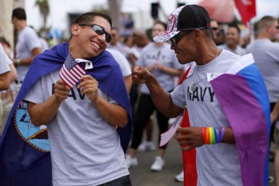 Matthew Avila, active duty gunners mate 2nd class U.S. Navy, receives a punch in the arm from former EN2 U.S. Navy''s Ray Cordero as they prepare to march in San Diego