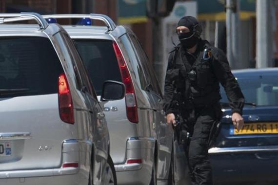 A special French GIPN intervention police member arrives at the scene where a man claiming to be a member of al Qaeda has taken four hostages, including the bank manager, in a bank in Toulouse