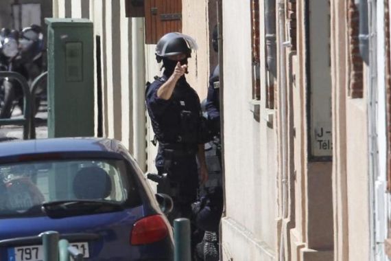 French Police officers cordon off the street where a man claiming to be a member of al Qaida has taken four hostages in a bank