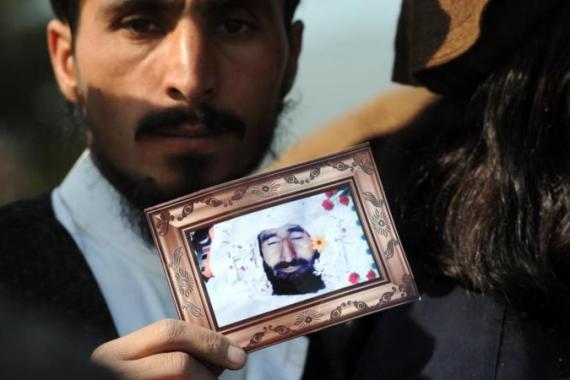A Pakistani tribesman shows a photograph
