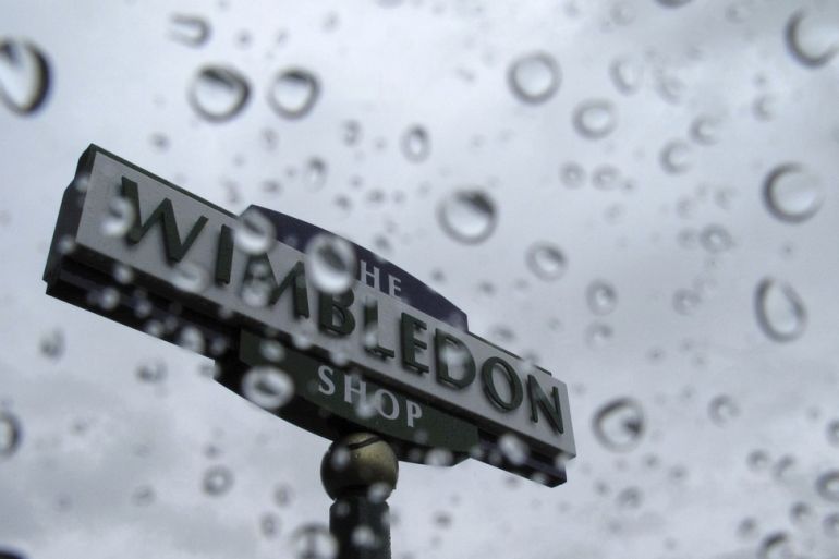 A Wimbledon sign is seen in the rain at the Wimbledon tennis championships in London