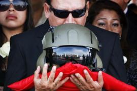 The father of Captain Nancy Flores kiss her pilot helmet during her funeral in Lima