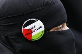 A pro-Palestinian demonstrator wears a Free Palestine badge during a protest march to the Israeli embassy in London