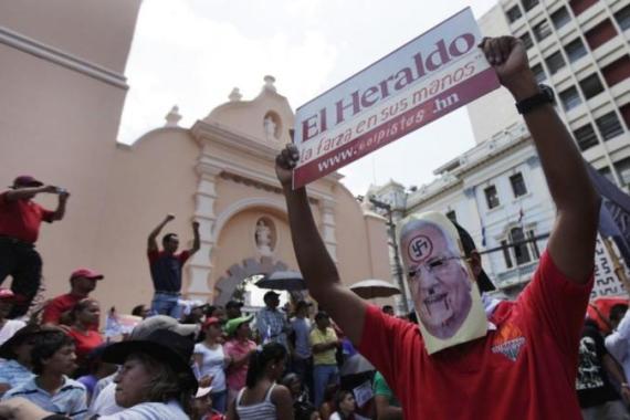 A supporter of Honduras'' ousted President Manuel Zelaya wears a mask of Honduras'' de facto ruler Roberto Micheletti during a rally to commemorate Honduras'' independence in Tegucigalpa