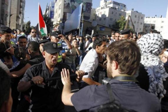 A member of the Palestinian security forces scuffles with a journalist in Ramallah