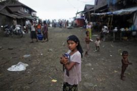 Myanmar Rohingya girl carries her books through a fish market on her way to school in the town of Sittwe