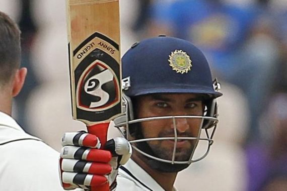 India''s Pujara raises his bat to celebrate scoring a half century during the first day of their first test cricket match against New Zealand in Hyderabad