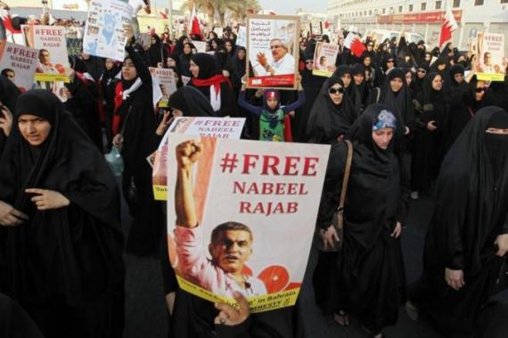 Protesters holding posters of Nabeel Rajab and Ibrahim Sharif demand for their release during an anti-government march organised by al-Wefaq opposition party in Budaiya