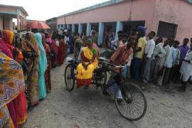 Elderly voters ride on a cycle rickshaw