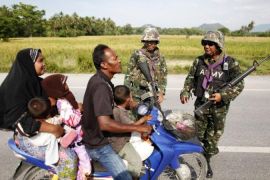 Thai soldiers talk to a Muslim family they stopped during a patrol in the troubled Yala province in southern Thailand