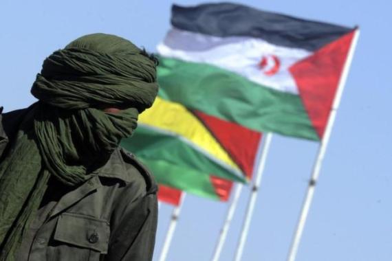 Near a Sahrawi flag a Sahrawi man looks