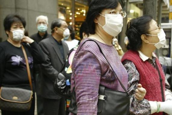 Hong Kong people wear masks as they wait