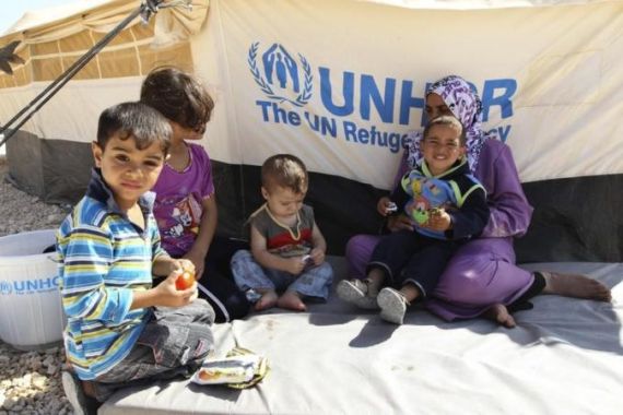 A Syrian refugee woman sits with her children during a visit by UNHCR Guterres and Jordan''s Foreign Minister Judeh to the Al Zaatri refugee camp in Mafraq