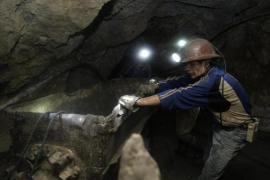 A Bolivian miner transports minerals inside the El Rosario mine in Potosi