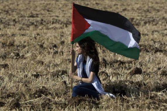 An Arab Israeli protestors holds up Pale