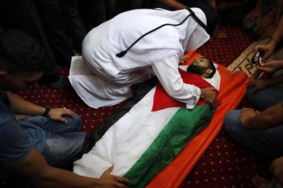 Palestinian man touches body of gunman during funeral in Gaza City