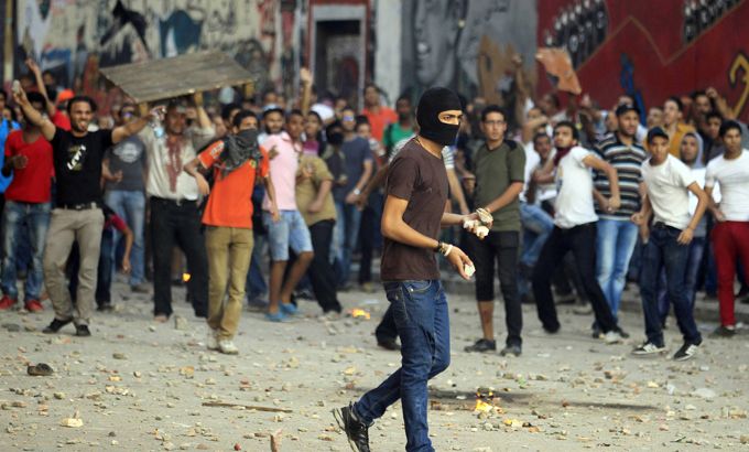 An anti-Muslim Brotherhood demonstrator prepares to throw stones during clashes with supporters of the Muslim Brotherhood