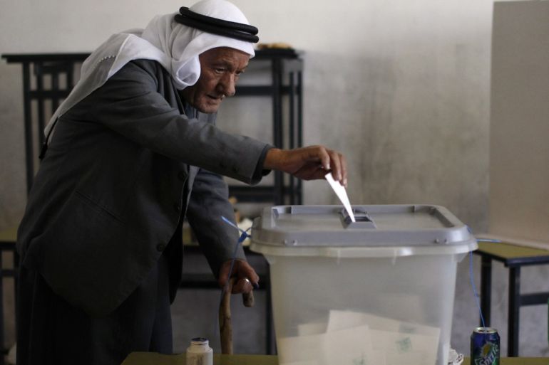 A Palestinian man casts his ballot for municipal elections at a polling station in the West Bank village of Shiyoukh