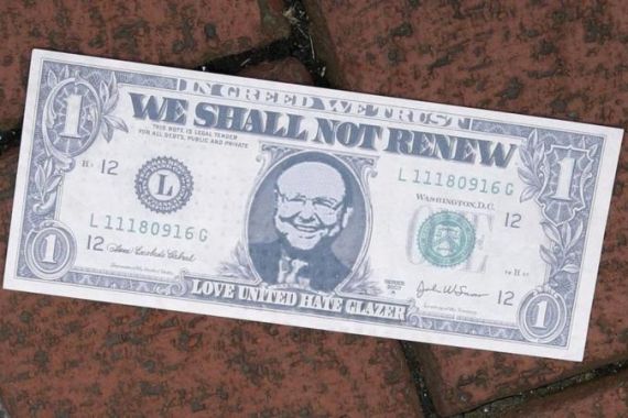 File photo of fake dollar bill bearing the face of Malcolm Glazer lies near the main entrance to Old Trafford as Manchester United supporters demonstrate against their American owners in Manchester