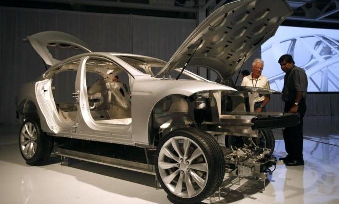 Visitors view the chassis of a Tesla Model S sedan displayed at the Tesla factory in Fremont