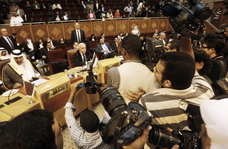 Members of the media compete to film Qatar''s Prime Minister Sheikh Hamad bin Jassem Al-Thani and Palestinian Foreign Minister Riyad al-Malki at the Arab League headquarters in Cairo